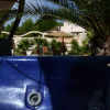 Jacuzzi blu all'aperto con palme sullo sfondo.