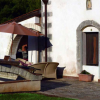 Edificio in pietra con patio e ombrellone.