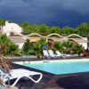 Piscina con lettini e giardino tropicale.