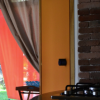 Cucina con mattoni e tende rosse.