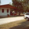 Una casa mobile con veranda in un campeggio. Vicino c'è un'auto parcheggiata.