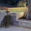 Area piscina con albero e muretto.