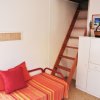 Divano rosso e scala a pioli, arredo semplice e colorato.