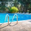 Piscina blu circondata da lettini bianchi.