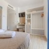 Camera hotel con letto matrimoniale, TV e guardaroba aperto.