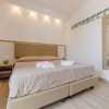 Letto matrimoniale con cuscini, specchio e tendaggi blu.