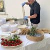 Uomo prepara cibo su tavolo con pomodori e utensili.