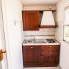 Cucina con mobili in legno e fornello a gas.