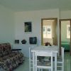 Interno di una stanza con tavolo, divano e televisore.