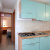 Cucina con mobili azzurri e camera sullo sfondo.