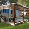Casa mobile con veranda in legno e tavolo fuori.