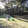 Due persone sedute davanti a una tenda in un bosco.