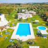 Una piscina all'aperto con lettini e giardino verde.