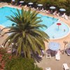 Piscina circondata da lettini e ombrelloni a righe.