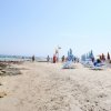 Spiaggia con lettini e ombrelloni colorati.