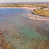 Spiaggia vista dall'alto con mare limpido.